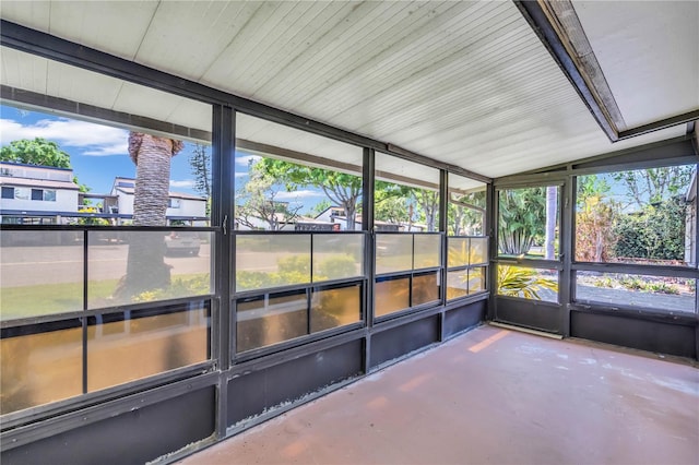 unfurnished sunroom featuring a healthy amount of sunlight and vaulted ceiling