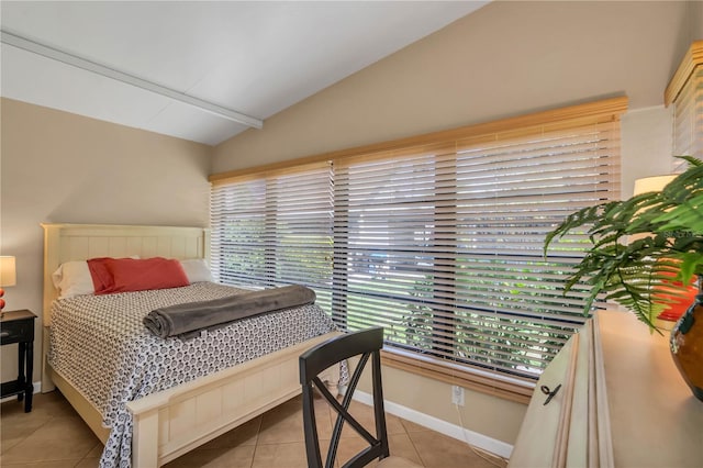 tiled bedroom featuring vaulted ceiling and multiple windows