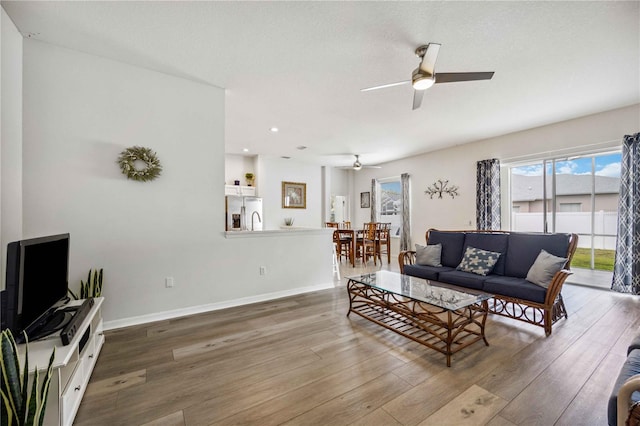 living room with dark hardwood / wood-style floors and ceiling fan