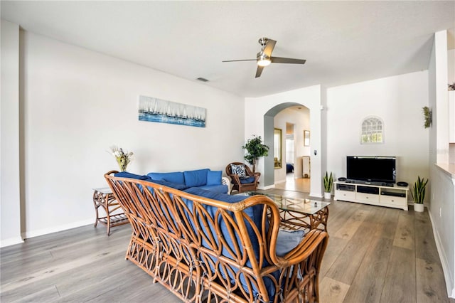 living room with ceiling fan and light hardwood / wood-style flooring