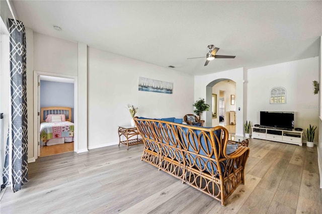 living room with ceiling fan and light wood-type flooring