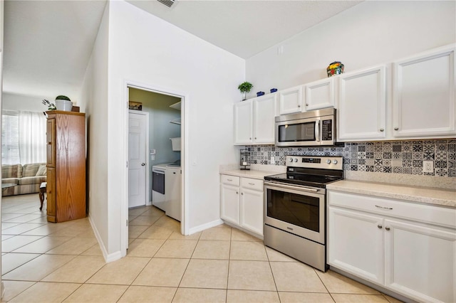 kitchen with light tile floors, white cabinets, backsplash, and stainless steel appliances