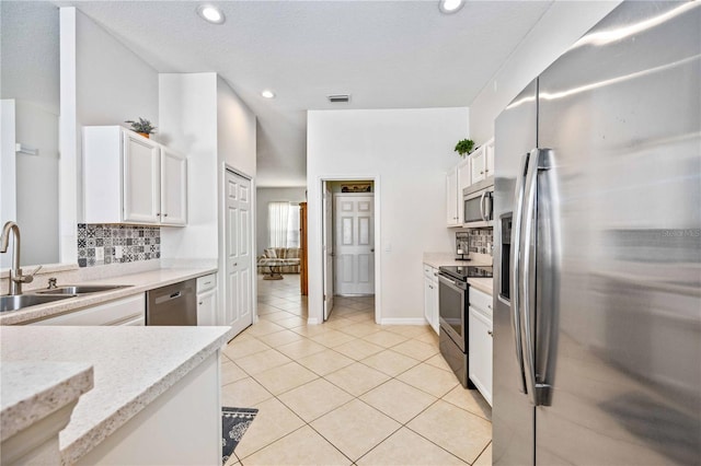 kitchen featuring backsplash, stainless steel appliances, and white cabinetry