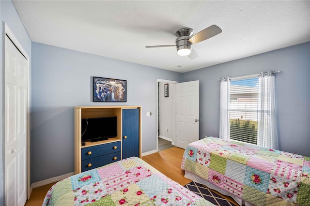 bedroom with a closet, ceiling fan, and light hardwood / wood-style flooring