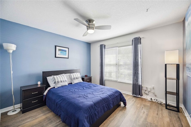 bedroom featuring a textured ceiling, ceiling fan, and hardwood / wood-style flooring