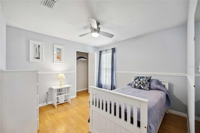 bedroom with a closet, ceiling fan, and light hardwood / wood-style flooring