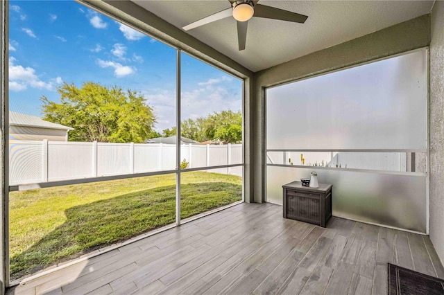 unfurnished sunroom with ceiling fan