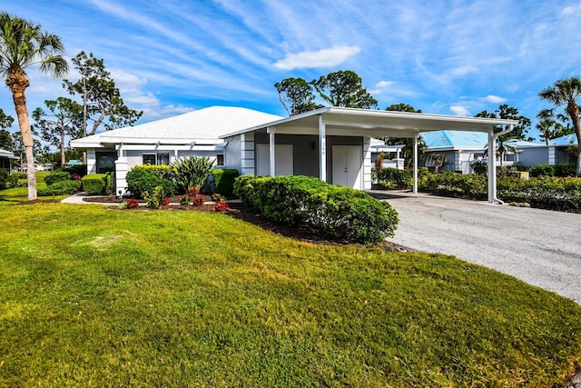 view of front of property with a carport and a front lawn