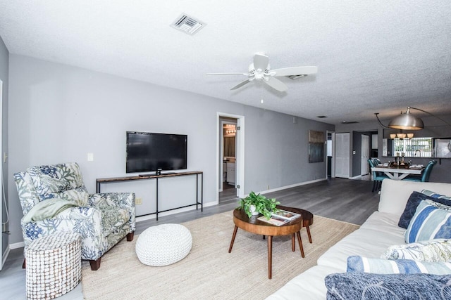 living room with ceiling fan, hardwood / wood-style floors, and a textured ceiling