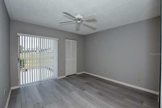 unfurnished room featuring wood-type flooring, a textured ceiling, and ceiling fan