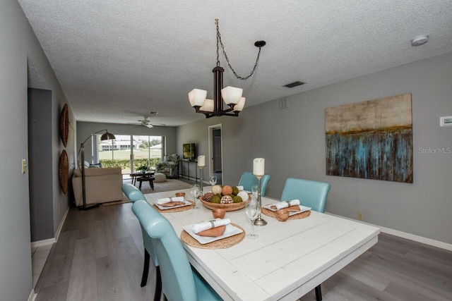 dining area featuring ceiling fan with notable chandelier, hardwood / wood-style floors, and a textured ceiling