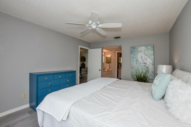 bedroom with ceiling fan, connected bathroom, a textured ceiling, and light hardwood / wood-style floors