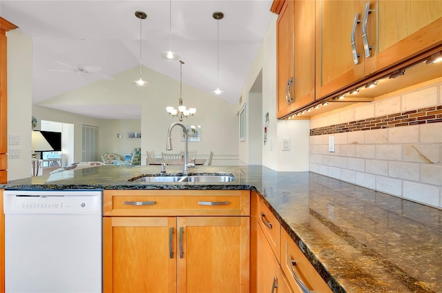 kitchen with decorative light fixtures, lofted ceiling, sink, white dishwasher, and kitchen peninsula