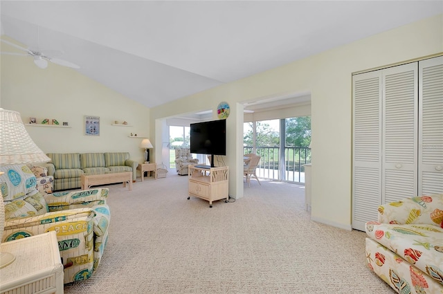 carpeted living room with ceiling fan and vaulted ceiling