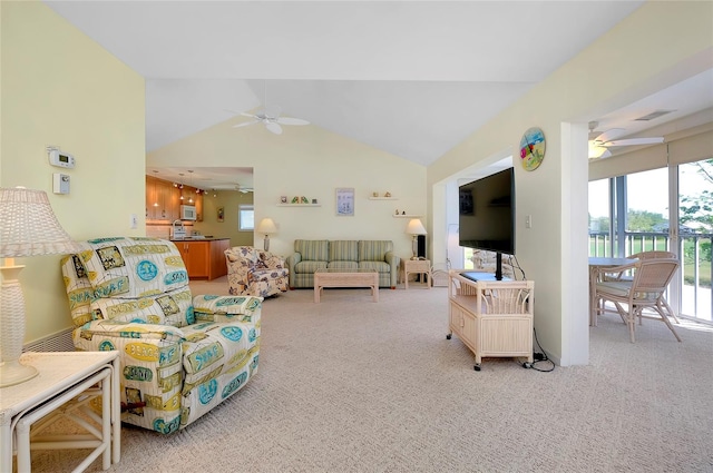 carpeted living room with ceiling fan, plenty of natural light, and vaulted ceiling