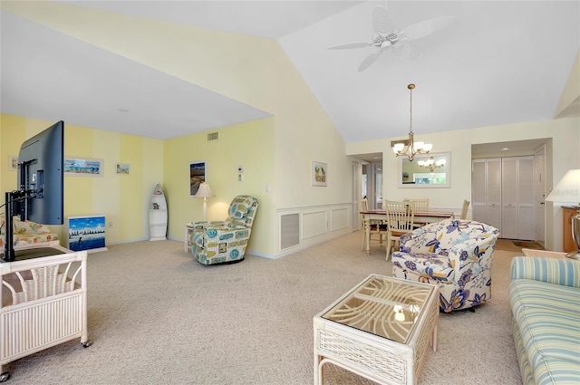 carpeted living room featuring high vaulted ceiling and ceiling fan with notable chandelier