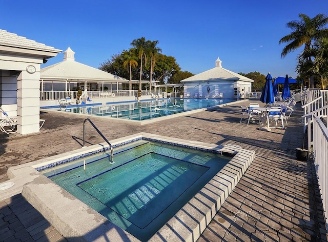 view of swimming pool featuring a patio area and a hot tub