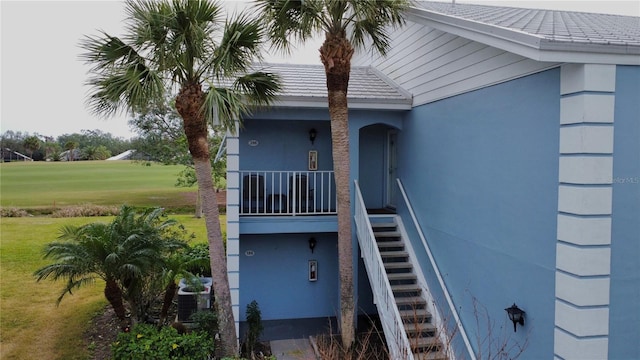 property entrance featuring a yard, central AC, and stucco siding