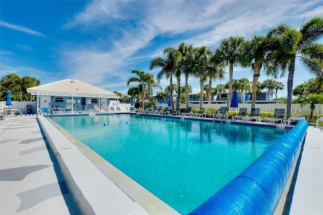 pool with a patio area and fence