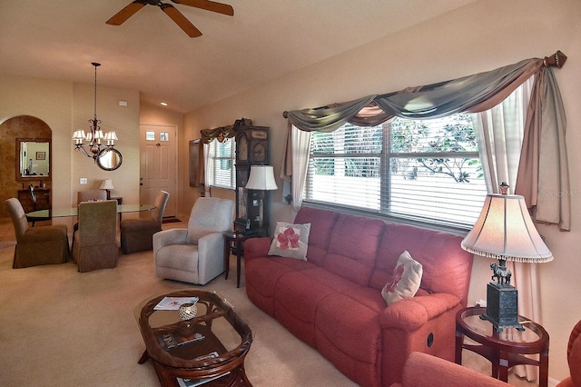 living room with lofted ceiling, light carpet, and ceiling fan with notable chandelier