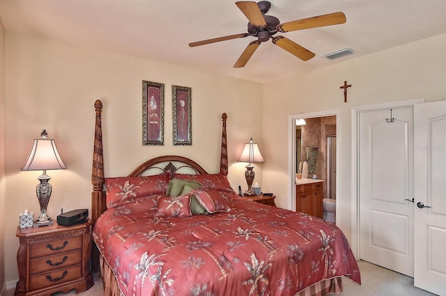 bedroom featuring ceiling fan, connected bathroom, and light carpet