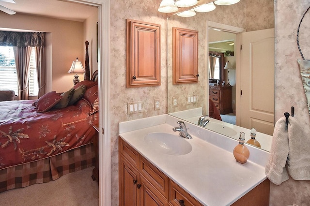 bathroom with ceiling fan and vanity with extensive cabinet space