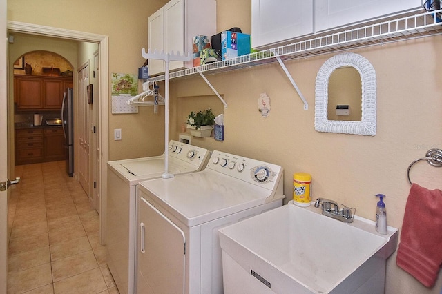 laundry area with cabinets, sink, light tile floors, separate washer and dryer, and hookup for a washing machine