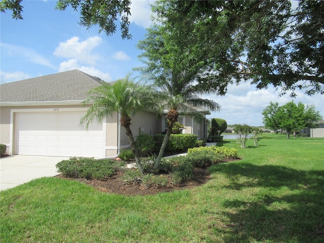 view of front of property featuring a front lawn and a garage