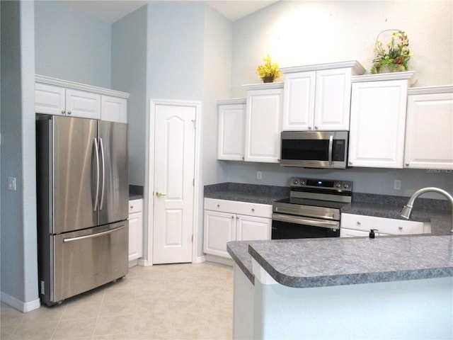 kitchen with white cabinets, light tile floors, and appliances with stainless steel finishes