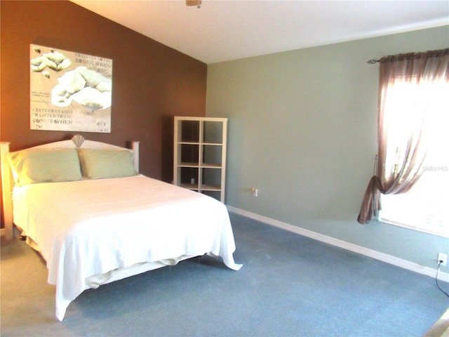 carpeted bedroom with lofted ceiling