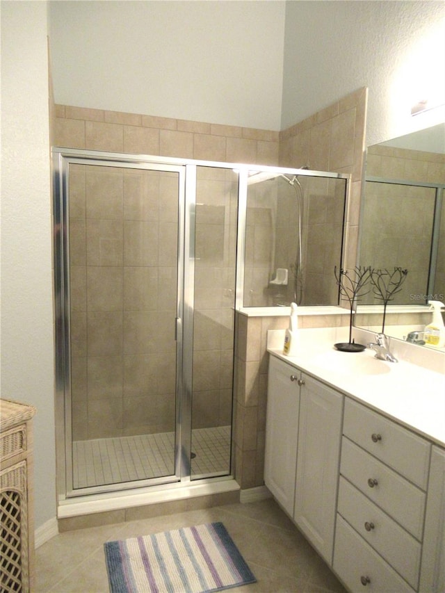 bathroom with tile flooring, walk in shower, and vanity