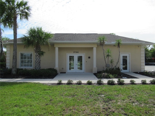 rear view of house featuring french doors and a yard