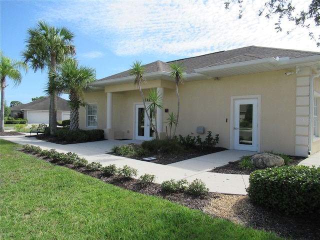 exterior space featuring a yard and french doors