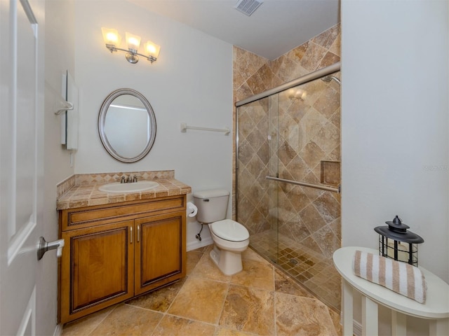 bathroom featuring vanity, tile flooring, a shower with shower door, and toilet