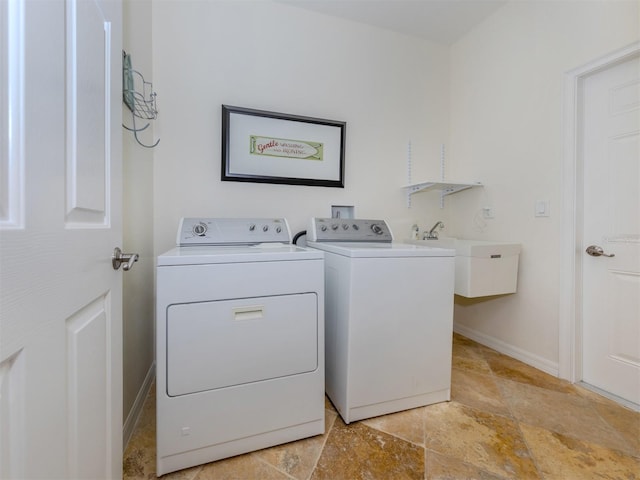 laundry room featuring washer and dryer, light tile floors, and sink