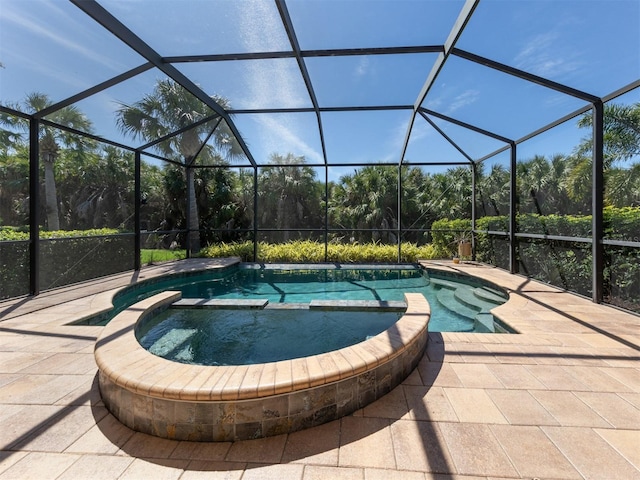 view of swimming pool featuring a patio area, an in ground hot tub, and a lanai