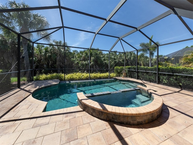 view of pool with an in ground hot tub, glass enclosure, and a patio area