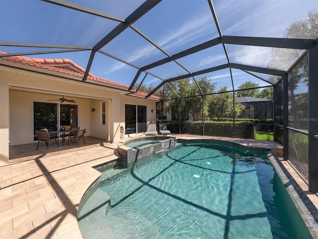 view of swimming pool featuring a patio area, an in ground hot tub, ceiling fan, and glass enclosure