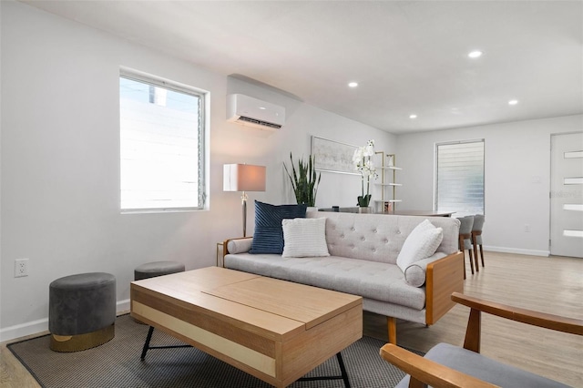 living room with an AC wall unit and light wood-type flooring