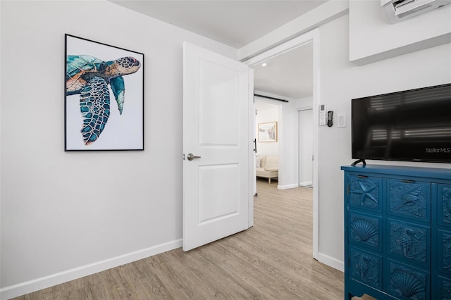 interior space featuring a wall mounted AC and light hardwood / wood-style floors