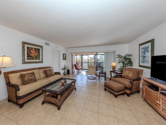 tiled living room featuring a textured ceiling