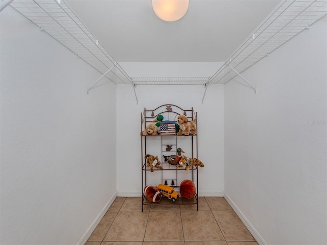 walk in closet with light tile patterned floors