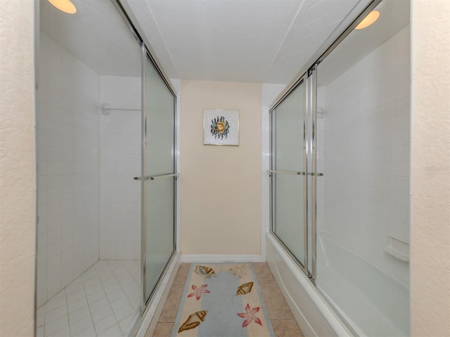 bathroom with tile patterned floors and bath / shower combo with glass door