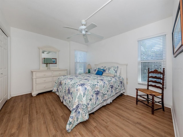 bedroom featuring hardwood / wood-style floors, ceiling fan, and a closet