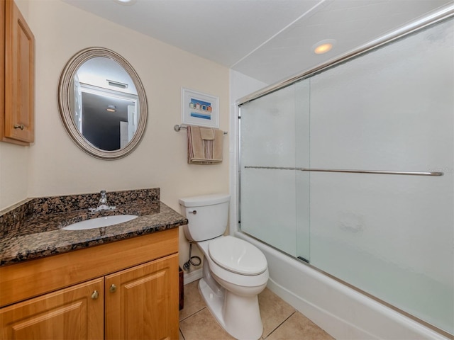 full bathroom featuring toilet, vanity, tile patterned floors, and shower / bath combination with glass door