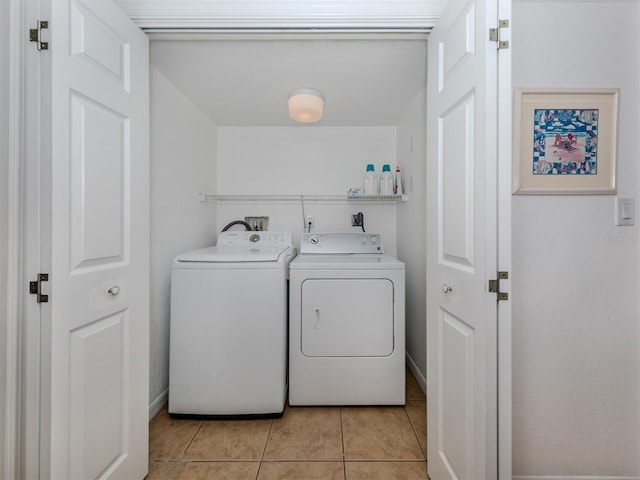 washroom featuring washer and clothes dryer and light tile patterned floors