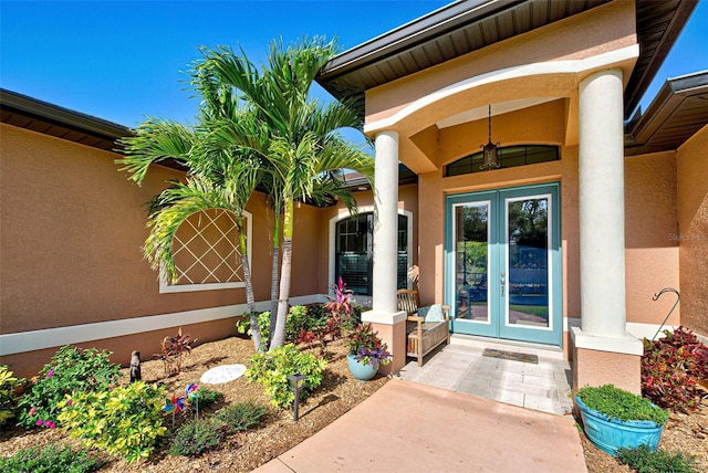 view of exterior entry featuring french doors and covered porch