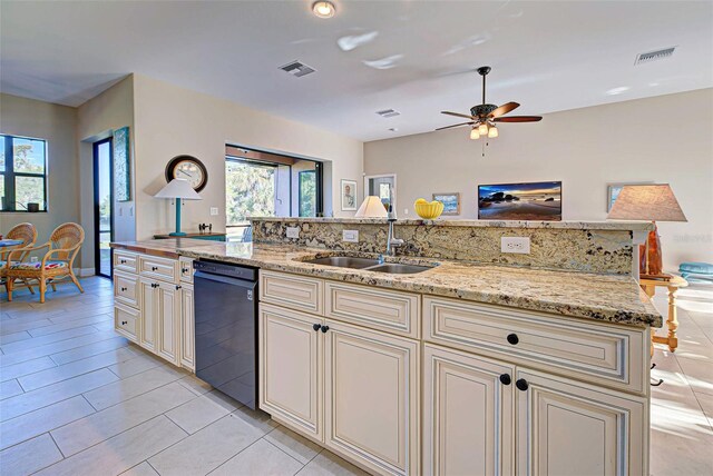 kitchen with ceiling fan, sink, light stone counters, cream cabinetry, and dishwasher