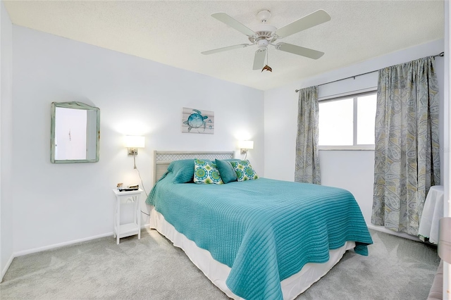 carpeted bedroom featuring a textured ceiling and ceiling fan