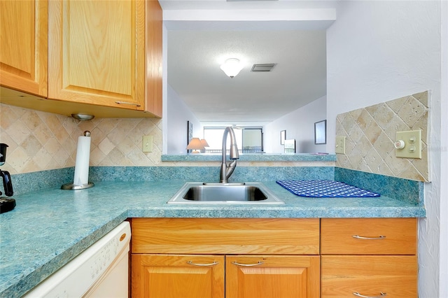 kitchen featuring backsplash, dishwasher, and sink